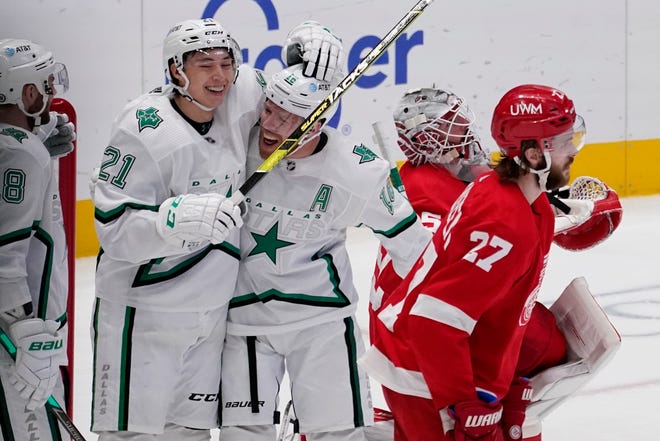 Dallas Stars' Jason Dickinson, left, Jason Robertson (21), and Joe Pavelski (16) celebrate a goal by Pavelski as Detroit Red Wings' Michael Rasmussen (27) and Jonathan Bernier, rear, skate past in the first period of an NHL hockey game in Dallas, Tuesday, April 20, 2021.