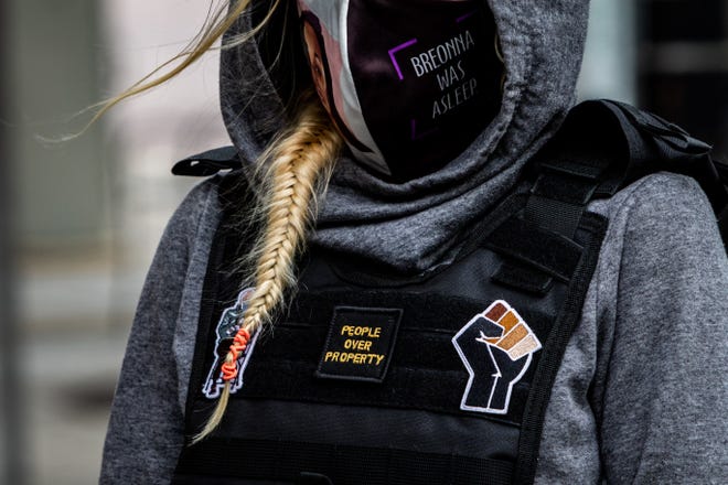 A protester wears a plate carrier with various patches in downtown Grand Rapids on Tuesday, April 20, 2021, in response to the Derek Chauvin trial verdict in the death of George Floyd.