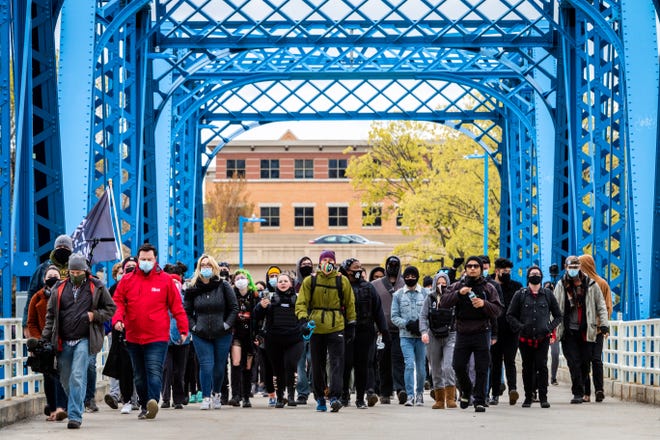 Protesters and media march across the "Blue Bridge" in downtown Grand Rapids on Tuesday, April 20, 2021, in response to the Derek Chauvin trial verdict in the death of George Floyd.