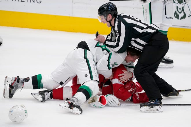 Linesmen Libor Suchanek (60) attempts to break up a fight between Dallas Stars defenseman Sami Vatanen (45) and Detroit Red Wings center Vladislav Namestnikov, bottom, in the first period of an NHL hockey game in Dallas, Tuesday, April 20, 2021.