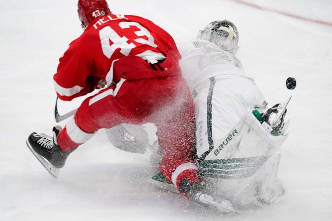 Detroit Red Wings left wing Darren Helm (43) and Dallas Stars goaltender Jake Oettinger collide on the ice as they two were trying to reach a loose puck in the third period of an NHL hockey game in Dallas, Tuesday, April 20, 2021. Oettinger was charged with tripping on the play.