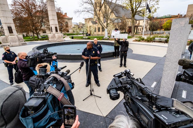 Grand Rapids Police Chief Eric Payne gives a press conference as protesters stand behind him holding signs and chanting in downtown Grand Rapids on Tuesday, April 20, 2021, in response to the Derek Chauvin trial verdict in the death of George Floyd.