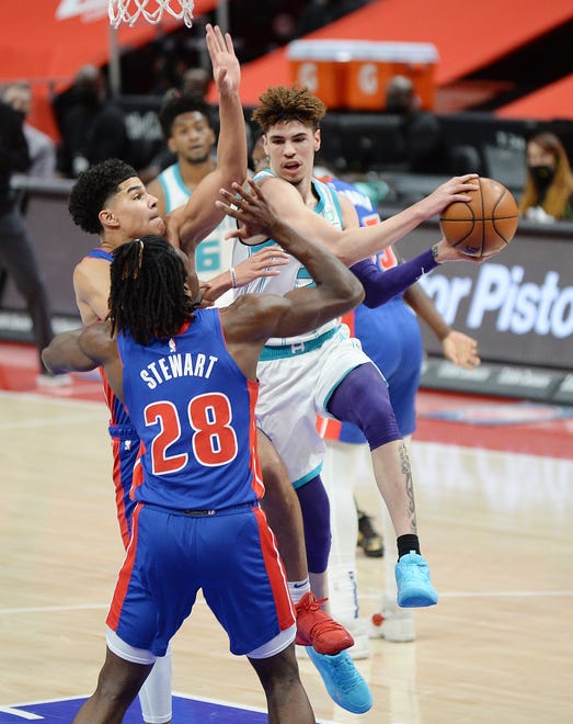Charlotte Hornets' LaMelo Ball makes a pass around Detroit Pistons', from left to right, Killian Hayes and Isaiah Stewart in the first quarter of their game at Little Caesars Arena in Detroit, Tuesday night, May 4, 2021.