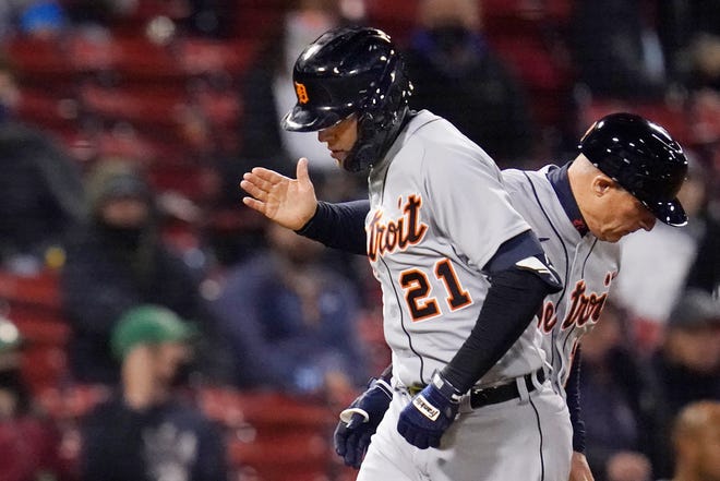 Detroit Tigers' JaCoby Jones, left,  is congratulated by third base coach Chip Hale, right, while rounding the bases on his three-run home run during the sixth inning.