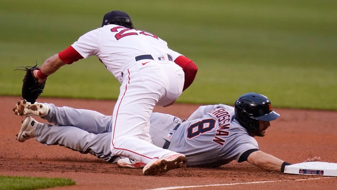 Detroit Tigers' Robbie Grossman (8) dives back safely to first as Boston Red Sox first baseman Bobby Dalbec catches the pick-off throw during the first inning.