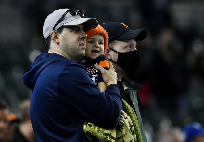 From left, Brent Kratochvil, 38, of Royal Oak holds his son, Leo, 2, with friend, Matt Boyd, 38, during the seventh inning stretch.  Detroit Tigers vs Kansas City Royals at Comerica Park in Detroit on May 12, 2021.  Tigers win, 4-2.
(Robin Buckson / The Detroit News)