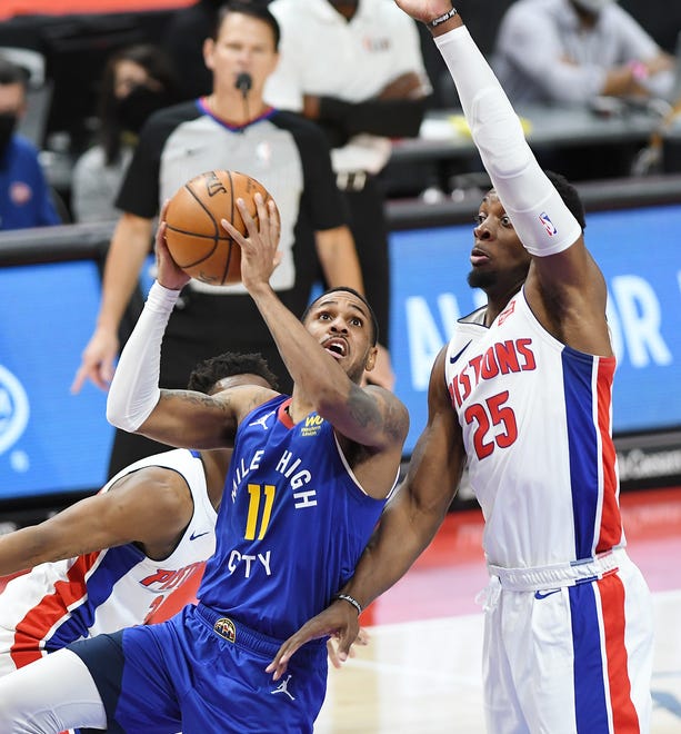 Nuggets' Monte Morris, (Flint native), scores over Pistons' Tyler Cook in the fourth quarter. The Nuggets defeated the Pistons, 104-91, Friday, May 14, 2021 at Little Caesars Arena in Detroit.