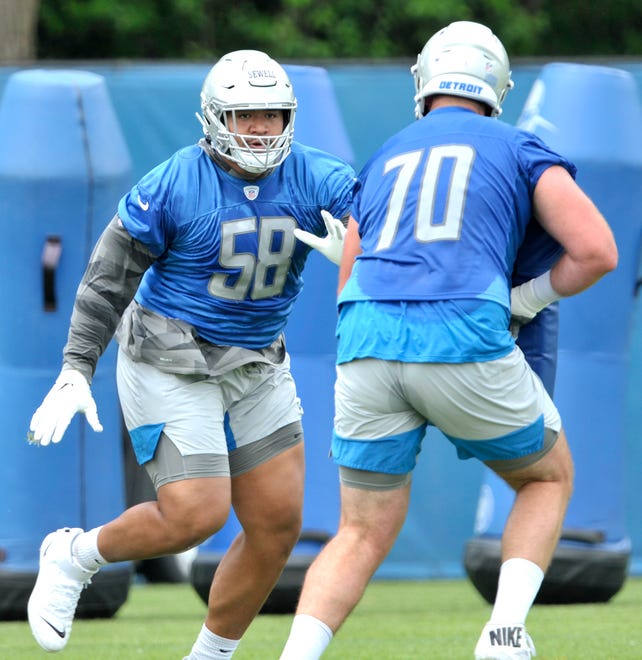 Lions offensive tackles Penei Sewell (58) and Dan Skipper (70) run through blocking drills during practice.