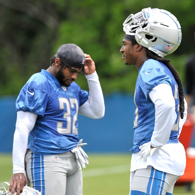 Lions running backs D'Andre Swift (32) and Jamaal Williams (30) take a break during practice.