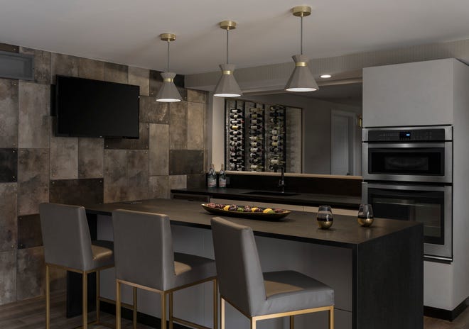 This Toll Brothers home features a bar designed by Scavolini Store Detroit positioned below a mounted TV. Media equipment can be stored in another room of the home designed by Laura Zender Design to keep the area cord-free.