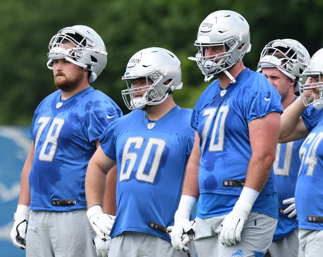 Detroit Lions rookie linemen Tommy Kraemer (78) and Drake Jackson (60) and three-year veteran Dan Skipper (70) during a break in the action.