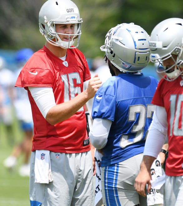Detroit Lions quarterback Jared Goff talks with running back D'Andre Swift during a break in the action.