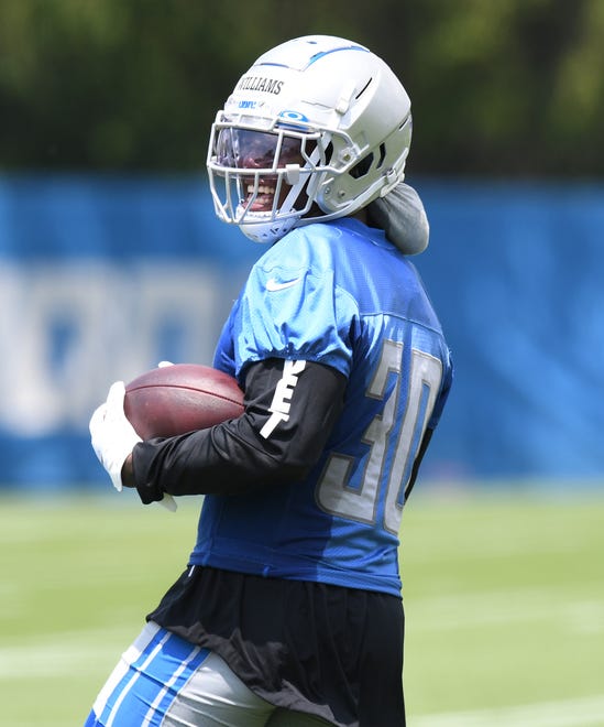 Detroit Lions running back Jamaal Williams looks back after a tough reception during drills.