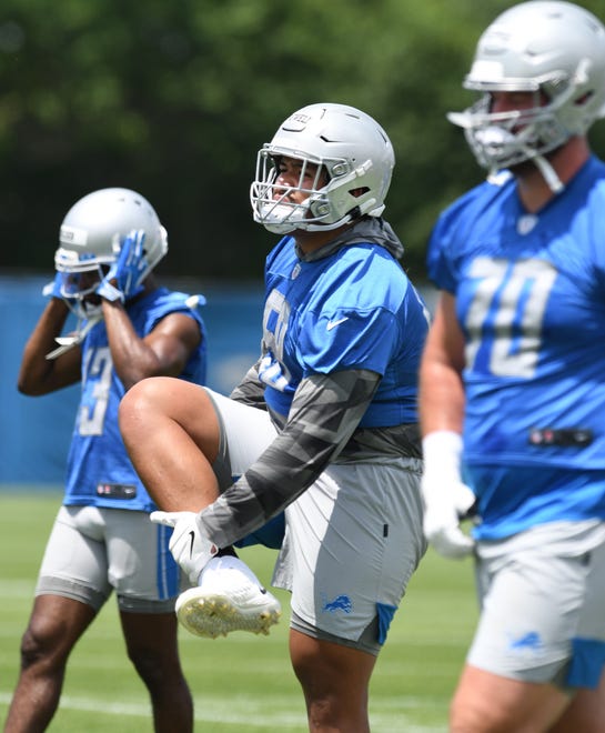 Detroit Lions rookie tackle Penei Sewell stretches out at the start of practice.
