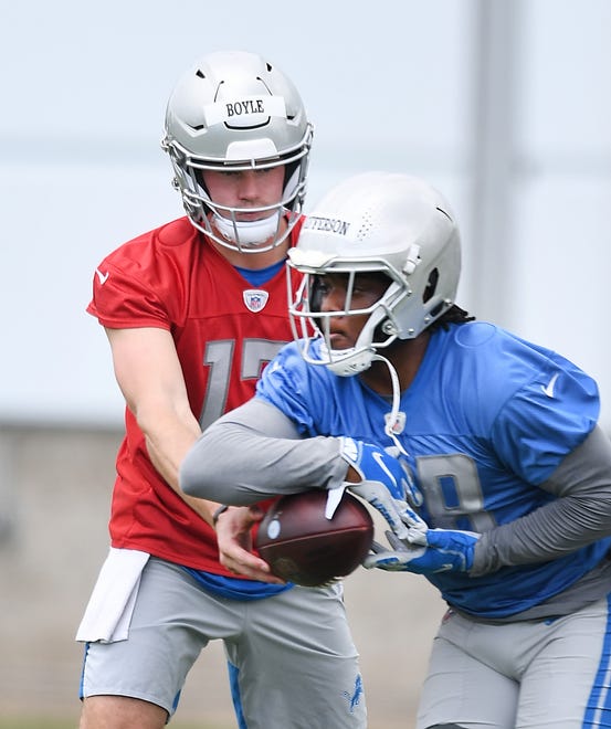 Lions quarterback Tim Boyle hands off to rookie running back Jermar Jefferson during drills.