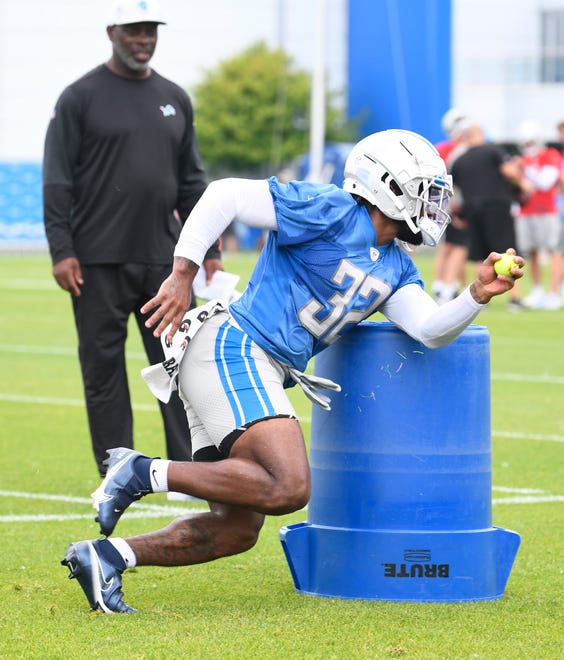 Lions offensive coordinator Anthony Lynn watches running back D'Andre Swift during drills.