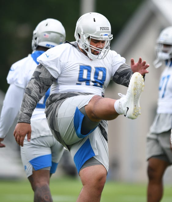 Lions defensive lineman John Penisini stretches out during warmups.