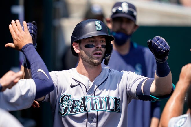 Seattle Mariners' Mitch Haniger is greeted in the dugout after his solo home run during the fifth inning.