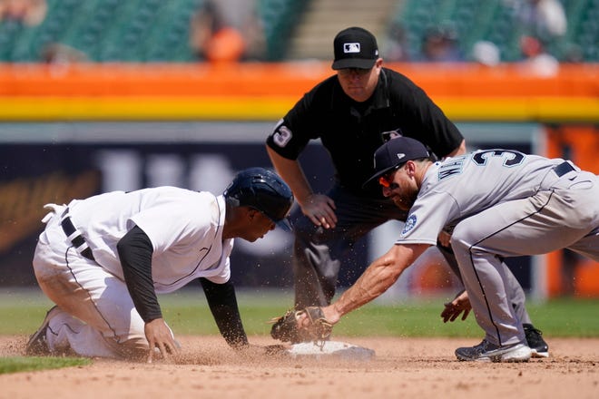 Detroit Tigers' Jonathan Schoop, left, safely beats the tag of Seattle Mariners second baseman Donovan Walton (31) as umpire Todd Tichenor looks on during the sixth inning.