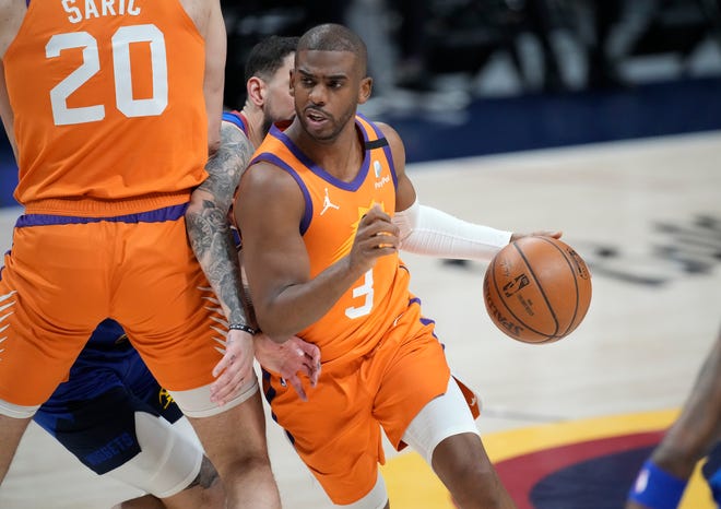 Phoenix Suns guard Chris Paul drives as Denver Nuggets guard Facundo Campazzo is slowed by screen by Suns forward Dario Saric during the first half.