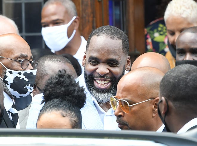 Former Detroit Mayor Kwame Kilpatrick makes his way through the crowd, waving and shaking hands, after preaching.