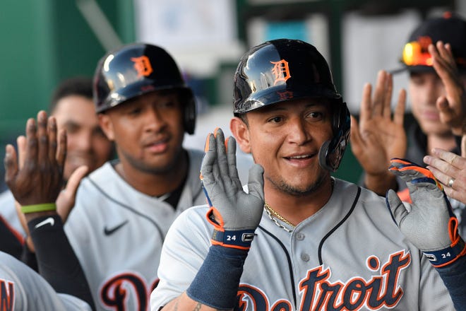 Tiger Miguel Cabrera, front, celebrates with teammates, including Jonathan Schoop, behind, after they scored two runs during the first inning.