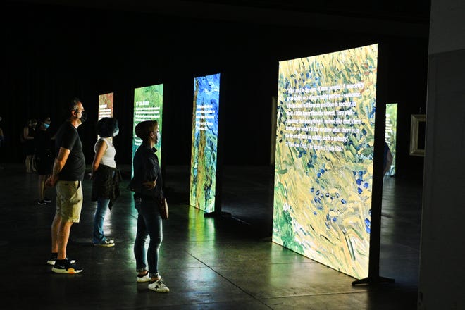 People walk through the Beyond Van Gogh exhibit during the first public day with more than 300 iconic artworks at the TCF Center in Detroit on Friday, June 25, 2021. Beyond Van Gogh uses cutting-edge projection technology to create an engaging journey into the world of Van Gogh.