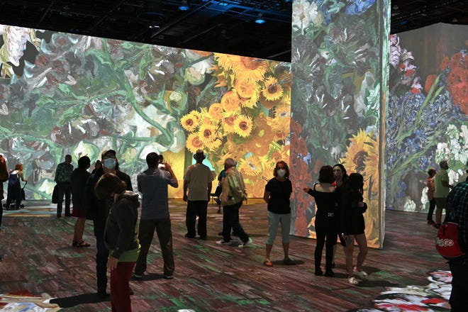 People walk through the immersive gallery at the Beyond Van Gogh exhibit during the first public day with more than 300 iconic artworks at the TCF Center in Detroit on Friday, June 25, 2021. Beyond Van Gogh uses cutting-edge projection technology to create an engaging journey into the world of Van Gogh.