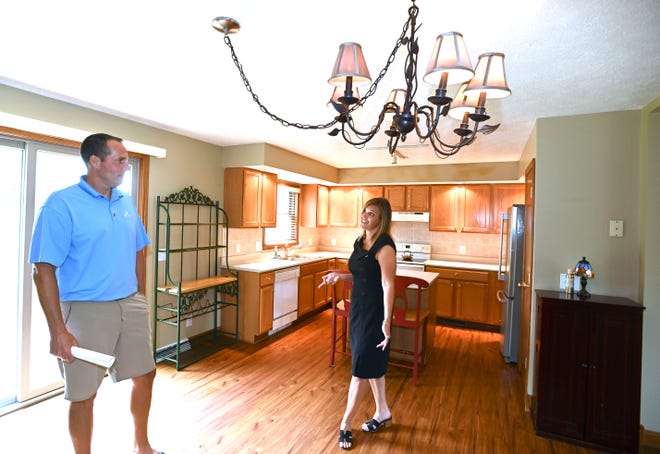 Sine and Monaghan real estate agent Danielle Boulier, right, of St. Clair Township shows off the kitchen and dining room this Boulder Creek Condo in East China Township to Todd Carlson of Clinton Township on July 15, 2021.