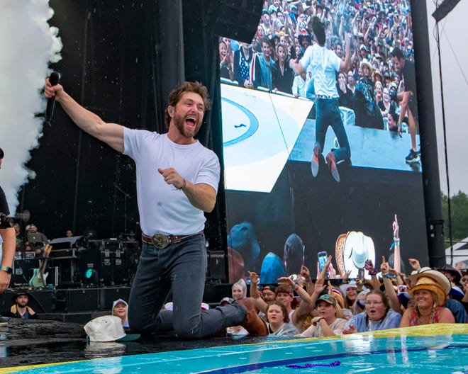 Chris Lane pumps his arm after falling on the rain soaked stage during the Faster Horses music festival on July 16, 2021, in Brooklyn.