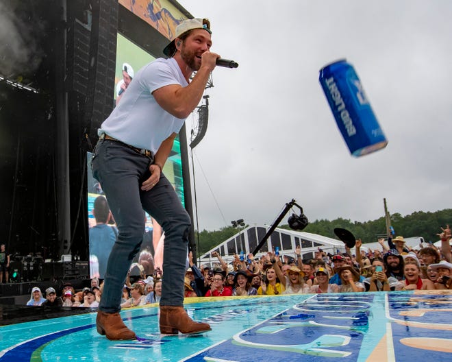 Chris Lane performs during the Faster Horses music festival as a beer can gets tossed to the stage on July 16, 2021, in Brooklyn.