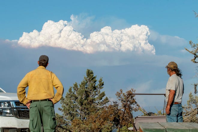 Fire Mitigation and Education Specialist Ryan Berlin (L) and  home owner Bob Dillon watch the Bootleg Fire smoke cloud from Dillon's home in Beatty, Oregon, on July 16, 2021. - The extreme drought-hit western United States braced for more wildfire destruction July 16, 2021 as efforts to contain a vast blaze scorching southern Oregon failed to progress, and dangerous dry lightning storms were forecast in California. The Bootleg Fire near Oregon's border with California grew overnight to 240,000 acres -- larger than New York City, and by far the biggest active blaze in the US -- while remaining just seven percent contained.