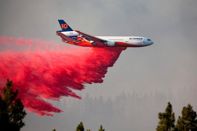 In this photo provided by the Bootleg Fire Incident Command, a DC-10 tanker drops retardant over the Bootleg Fire in southern Oregon, Thursday, July 15, 2021. Meteorologists predicted critically dangerous fire weather through at least Monday with lightning possible in both California and southern Oregon.