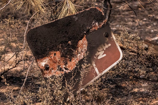 A sign marking a U.S. National Forest road is seen charred on the North East side of the Bootleg Fire, Wednesday, July 14, 2021, near Sprague River, Ore.
