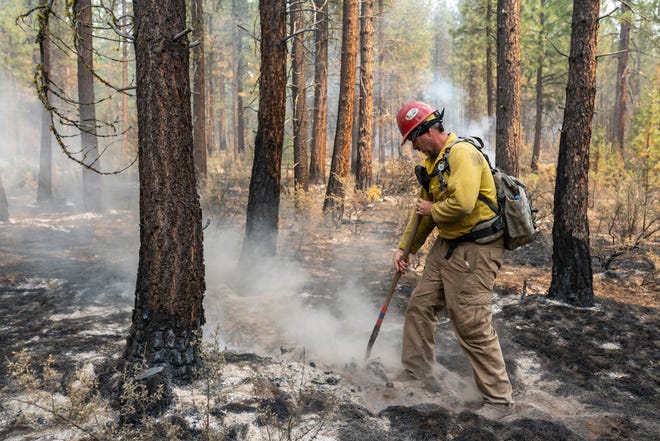 Firefighter Garrett Suza, with the Chiloquin Forest Service, mops up a hot spot on the North East side of the Bootleg Fire, Wednesday, July 14, 2021, near Sprague River, Ore.