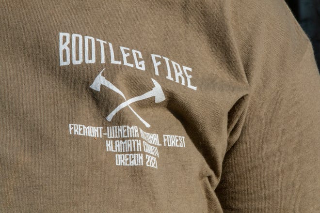 A Bootleg Fire shirt worn by an Oregon firefighter is pictured at the Bootleg Fire forward operating base in Bly, Oregon on July 15, 2021. - A brutal start to the wildfire season in the western United States and Canada worsened July 15, 2021 as a massive Oregon blaze exploded in dry, windy conditions and a new California blaze threatened communities devastated by the 2018 Camp Fire. The Bootleg Fire located 27 miles northeast of Klamath Falls, Oregon, caught fire nine days ago on July 6, 2021, due to an unknown cause. It is the largest burning wildfire in the United States at 227,234 acres as of July 15, 2021. The fire now stretches for 31 miles and grows between two and three miles a day. According to BLM Fire Mitigation and Education Specialist Ryan Berlin, there are approximately 2000 firefighters combating the Bootleg Fire. The fire is currently at 7% containment.
