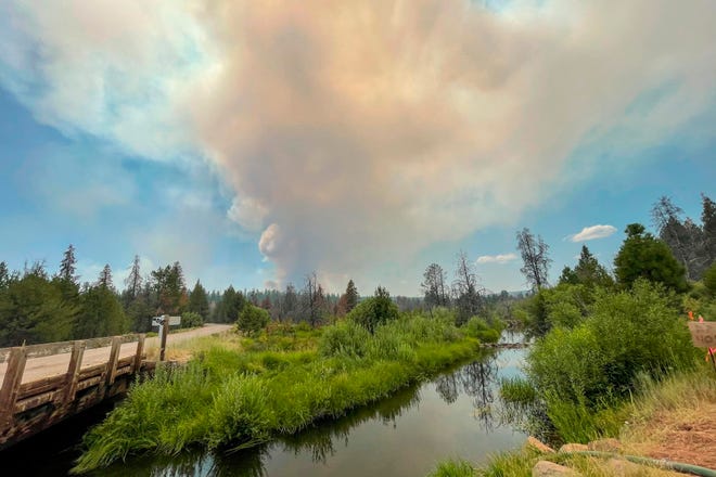 In this photo provided by the Bootleg Fire Incident Command, the Bootleg Fire burns in the background behind the Sycan Marsh in southern Oregon on Saturday, July 17, 2021. The destructive Bootleg Fire, one of the largest in modern Oregon history, has already burned more than 476 square miles (1,210 square kilometers), an area about the size of Los Angeles.