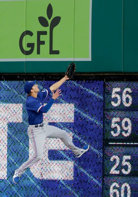 Rangers center fielder Eli White goes up against the wall in an unsuccessful attempt at catching a ball off the bat of Akil Baddoo that went for a home run in the fifth inning.
