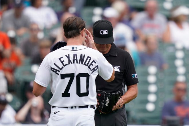 Umpire Chad Fairchild checks the glove on Tigers starting pitcher Tyler Alexander after Alexander was pulled during the fourth inning.