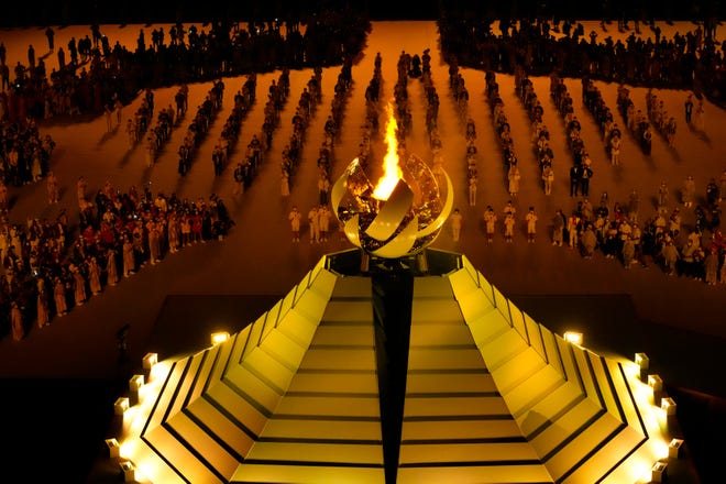The Olympic flame burns during the opening ceremony in the Olympic Stadium at the 2020 Summer Olympics, Friday, July 23, 2021, in Tokyo, Japan.