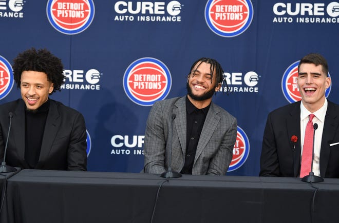 Cade Cunningham, Isaiah Livers and Luka Garza, share a laugh while listening to a story from Pistons coach Dwane Casey.