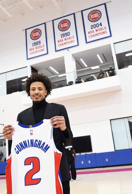 Cade Cunningham holds up his Pistons jersey after the Pistons introductory press conference.