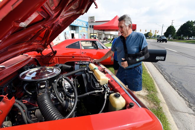 George Dean talks about the engine of his 1979 Lil Red Express Truck, parked along Gratiot during the 18th annual Clinton Township Gratiot Cruise, Sunday, Aug. 1, 2021 in Clinton Township, Mich.