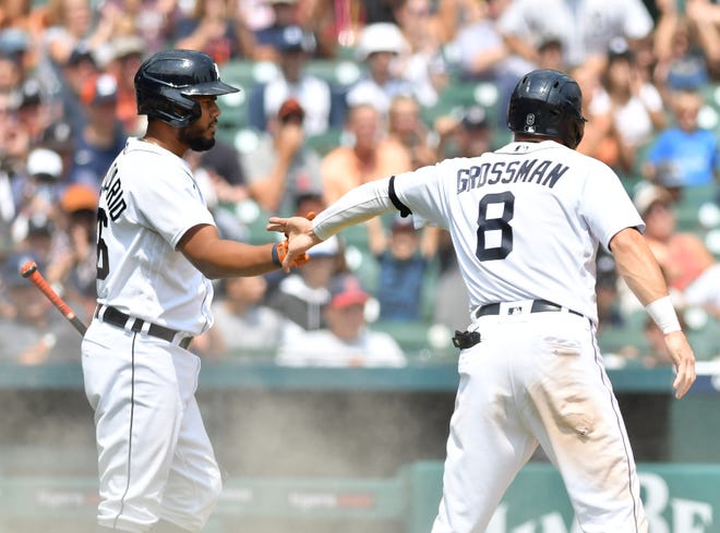 From left, the Tigers' Jeimer Candelario congratulates Robbie Grossman after Grossman scores in the sixth inning on a Miguel Cabrera sacrifice fly.