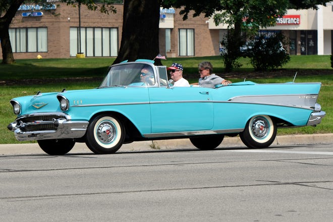 Macomb County Executive Mark Hackel rides in the backseat of a 1957 Chevrolet convertible, driven by car owner Gary Broad of Clinton Township during the 18th annual Clinton Township Gratiot Cruise, Sunday, Aug. 1, 2021 in Clinton Township, Mich.