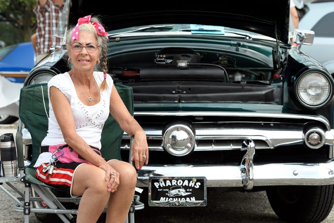 Linda Stilinovich fo Roseville sits next to her 1950 Ford, parked in a lot next to the McLaren-Macomb building during the 18th annual Clinton Township Gratiot Cruise, Sunday, Aug. 1, 2021 in Clinton Township, Mich.  (Jose Juarez/Special to Detroit News)