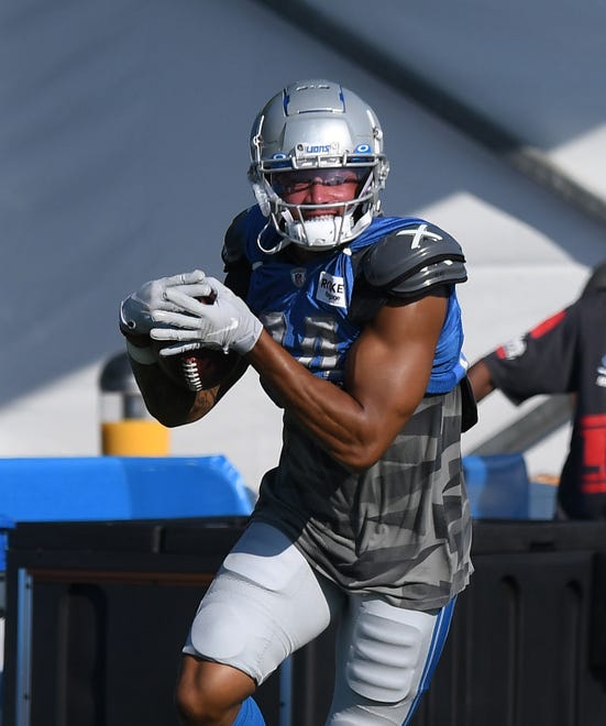 Lions tight end Alize Mack heads upfield after a reception during drills.
