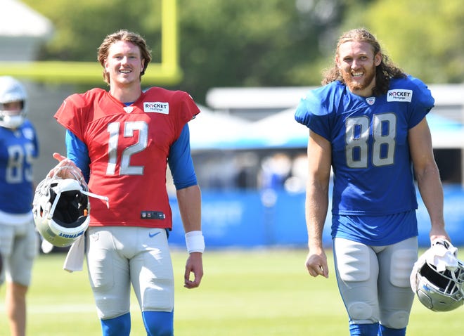 Lions quarterback Tim Boyle and tight end T.J. Hockenson head off the field after practice.