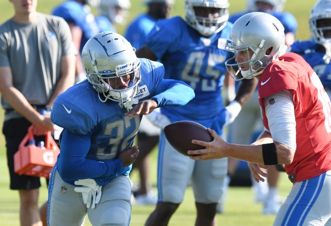 Lions running back D'Andre Swift fakes the handoff from quarterback Jared Goff during drills.