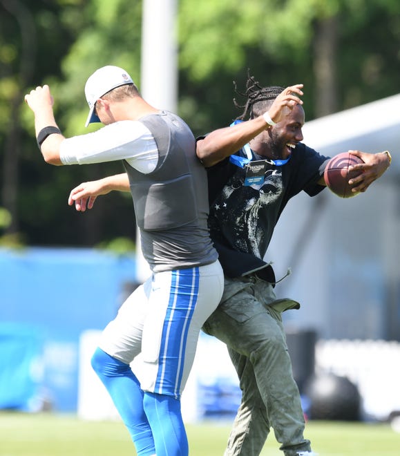 Tigers outfielder Akil Baddoo, right, goes up for a celebration with Lions quarterback Jared Goff after catching a pass during a visit to Lions training camp with teammate Derek Hill.